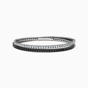 The 14k White Gold Black and White Diamond Double Wrap Bracelet 6.77 TCW features two rows: one with sparkling white diamonds and the other with striking black diamonds, creating a bold yet elegant contrast.