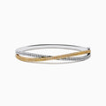 The Canare 14K Two Tone White and Yellow Diamond Criss Cross Bangle features intertwined bands of white and yellow gold, each adorned with sparkling diamonds for a dazzling effect.