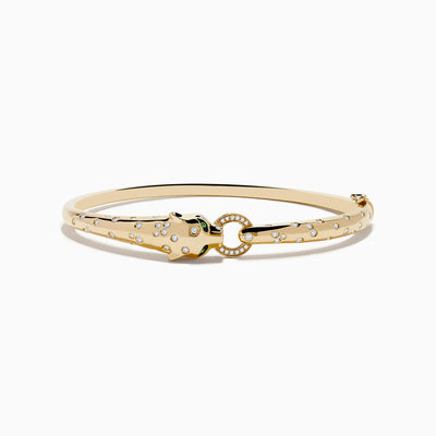 The Signature 14K Yellow Gold Diamond and Tsavorite Bangle features a panther’s head with tsavorite eyes, sparkling stones along the band, and a gem-encrusted circular link clasped in its mouth.