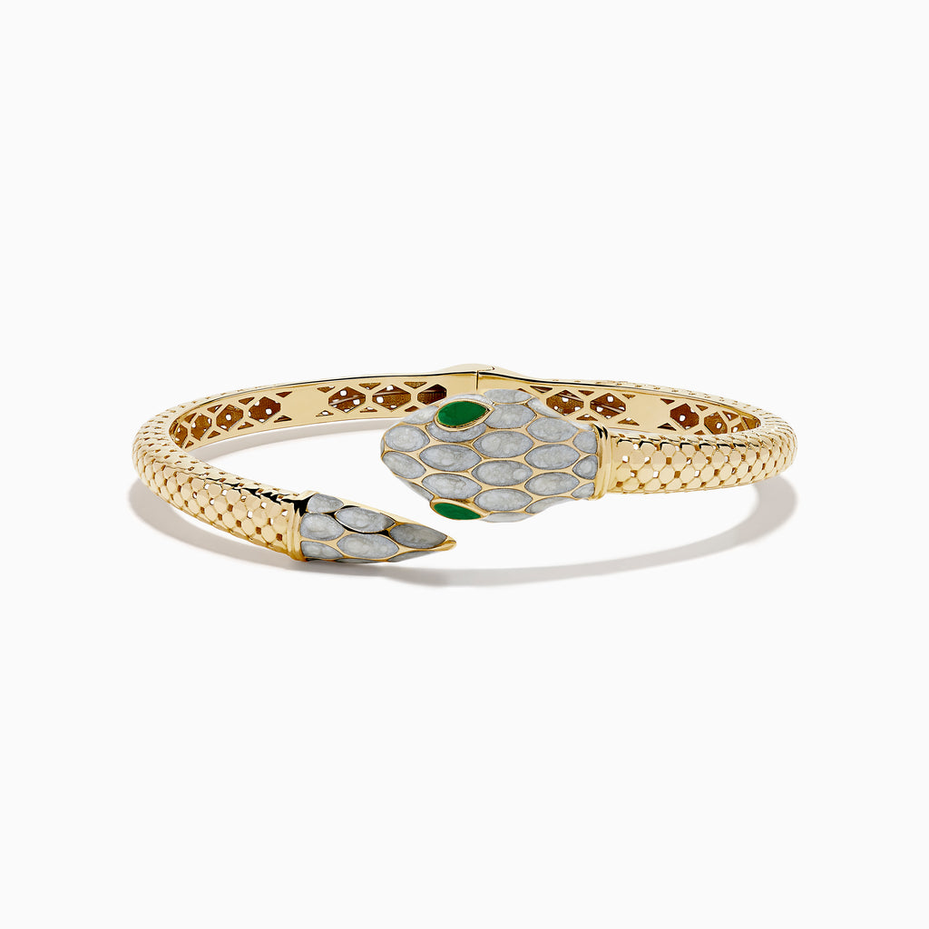 The 14K Yellow Gold White and Green Enamel Snake Bypass Bangle features a white and gold scale pattern on the head and tail, highlighted with green enamel eyes.