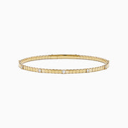 The 14K Yellow Gold Diamond Station Flexible Bangle features smooth rectangular links and evenly spaced round diamonds, offering minimalist elegance in a thin, flexible design perfect for any occasion.