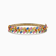 The Watercolors 14K Yellow Gold Multi Sapphire Bangle features marquise-cut sapphires in blue, green, pink, orange, and yellow, set in a leaf-inspired pattern, evoking the look of vibrant watercolors.