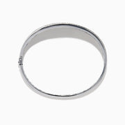 The 925 Sterling Silver Diamond Accented Bangle features a smooth, slightly curved center, two rows of sparkling stones along the edges, and a decorative lattice pattern inside.