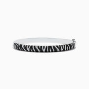 The 14k White Gold Black and White Diamond Zebra Print Bangle features a striking zebra stripe design with black and white diamond accents, elegantly set against plain white gold.