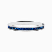 The Royale Bleu 14K White Gold Blue Sapphire and Diamond Bangle showcases a row of rectangular blue sapphires bordered by sparkling diamonds, elegantly set against a white background.