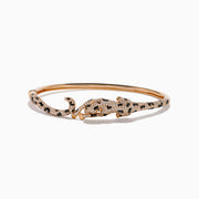 The Signature 14K Rose Gold Diamond and Emerald Panther Bangle features a panther design with its head and tail meeting at the front, adorned with sparkling diamonds and emeralds.