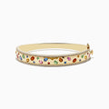 The Watercolor 14k Yellow Gold Bezel Set Multi Sapphire Bangle features vibrant sapphires set in 14k yellow gold, bordered with sparkling white diamonds for an elegant touch.