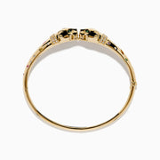 The Signature 14K Yellow Gold Multi Sapphire and Diamond Panther Bangle features two interlocking panther head motifs at the center, adorned with colorful sapphires and small diamonds.