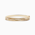 The 14K Yellow Gold Diamond Crossover Bracelet features multiple overlapping bands, some set with sparkling diamonds, for an elegant and intricate look.
