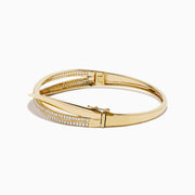 The 14K Yellow Gold Diamond Crossover Ribbon Bangle features overlapping bands in a crossover ribbon style, with some bands encrusted with sparkling diamonds for an elegant, layered look.
