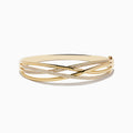 The Doro 14K Yellow Gold Diamond Crossover Bangle features interwoven gold bands, some set with sparkling white diamonds, for a sophisticated, shimmering look.