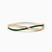 The Brasilica 14K Yellow Gold Emerald and Diamond Bangle features interwoven bands—one set with diamonds, the other with emeralds—beautifully displayed on a white background.