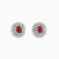 The Ruby Royale 18K White Gold Ruby and Diamond Earrings feature oval red rubies encircled by two halos of sparkling white diamonds, all set in elegant 18K white gold.