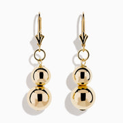 The 14K Yellow Gold Bead Dangle Earrings feature two stacked shiny gold spheres on each earring, suspended from gold hooks with a decorative top detail, shown against a plain white background.