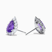 18K White Gold Purple Sapphire and Diamond Halo Earrings featuring pear-shaped purple sapphires encircled by a diamond halo. One earring is shown from the front, the other displays the back and side.