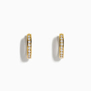 The 14K Yellow Gold Channel Set Diamond Mini Hoop Earrings feature a row of sparkling round diamonds, elegantly displayed on a white background.