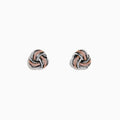 The 14K White Gold Pink Diamond Love Knot Earrings feature an intricate knot design in silver and rose gold tones, accented with sparkling pink diamonds. They are displayed against a plain white background.