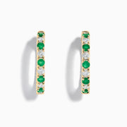 Displayed against a white background, these 14K yellow gold hoop earrings feature alternating emerald and diamond gemstones (3.58 TCW), making for a striking and elegant pair.