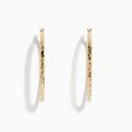 A pair of 14K Yellow Gold Crystal Cut Tube Hoops, large and textured, are displayed vertically on a white background with soft shadows beneath each earring.