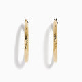 A pair of 14K Yellow Gold Chevron Cut Tube Hoops, displayed against a white background with soft shadows.
