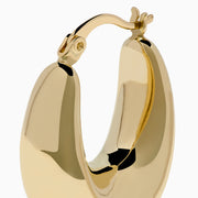 A pair of 14K yellow gold graduated oval chunky hoop earrings with a smooth, curved surface and clasp fastening, displayed on a white background.