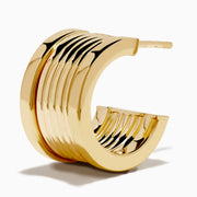 The 14K Yellow Gold Chunky Huggie Earrings feature a ridged, cylindrical design and are shown against a white background.