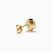 The 14K Yellow Gold Love Knot Stud Earrings are shown on a plain white background, highlighting their shiny finish.
