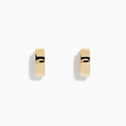 The 14K Yellow Gold Huggies are simple, small earrings with a smooth, shiny finish, shown on a plain white background.