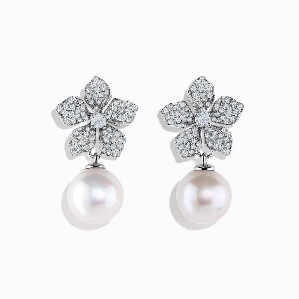 The 14K White Gold Diamond Flower and Fresh Water Pearl Drop Earrings feature diamond-studded flower tops with large round freshwater pearls dangling below, beautifully displayed against a white background.