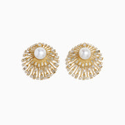 The 14K Yellow Gold Diamond and Pearl Sunburst Stud Earrings feature a large central pearl accented by radiating spokes adorned with clear, rectangular, and round gemstones in a striking sunburst design.