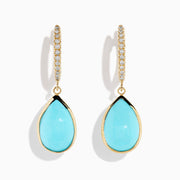 The 14K Yellow Gold Turquoise and Diamond Drop Earrings feature teardrop turquoise stones and sparkling diamonds along the hooks, shown on a white background.