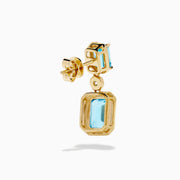 Elegant and symmetrical, the 14K Yellow Gold Blue Topaz and Diamond Drop Earrings display rectangular blue topaz stones with smaller gems above, separated by a sparkling diamond drop, set against a white background.