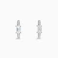 Lab Grown Diamond Emerald-Cut Huggie Earrings in 14K White Gold showcase rectangular center stones accented by small round diamonds, elegantly set and displayed against a plain white background.