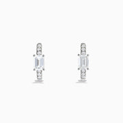 Lab Grown Diamond Emerald-Cut Huggie Earrings in 14K White Gold showcase rectangular center stones accented by small round diamonds, elegantly set and displayed against a plain white background.