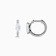 A pair of Lab Grown Diamond Marquise Huggie Earrings in 14K white gold, featuring dazzling lab-created gemstones, elegantly displayed on a plain white background.
