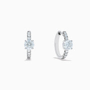 Lab Grown Diamond Round Huggie Earrings in 14K White Gold, featuring a central round diamond with vertical rows of smaller diamonds, displayed on a plain white background.