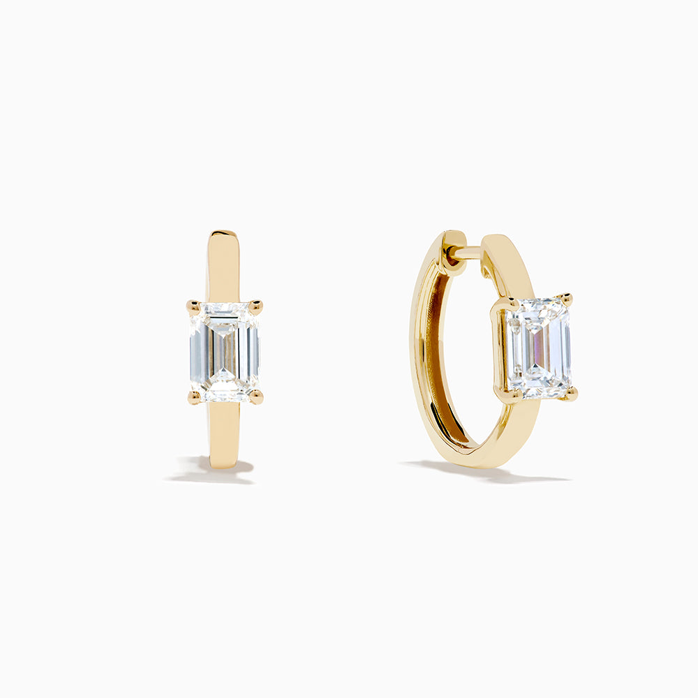 A pair of Lab Grown Diamond Emerald-Cut Huggie Earrings in 14K Yellow Gold is shown on a plain white background, each earring featuring a vertically set emerald-cut lab grown diamond at the center.