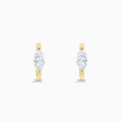 A pair of Lab Grown Diamond Marquise Huggie Earrings in 14K yellow gold, each with sparkling diamonds, shown against a plain white background.