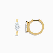 A pair of Lab Grown Diamond Marquise Huggie Earrings in 14K yellow gold, each with sparkling diamonds, shown against a plain white background.