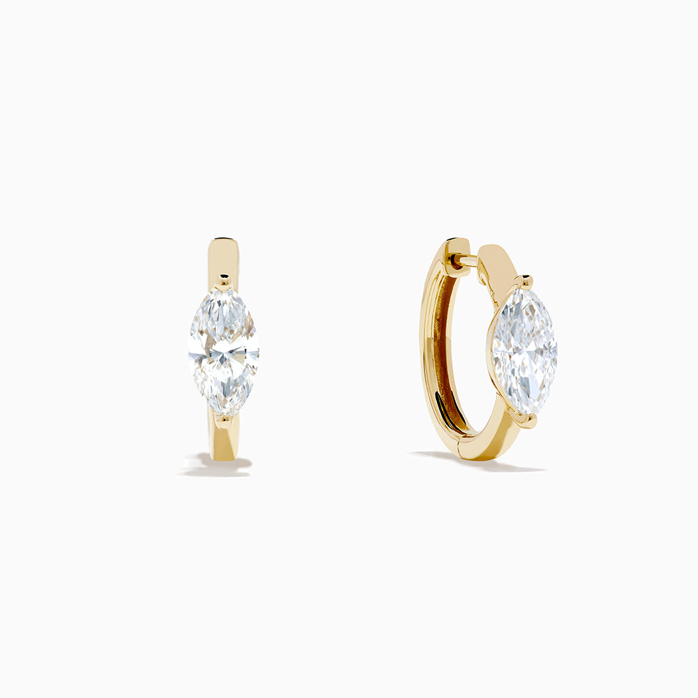 A pair of Lab Grown Diamond Marquise Huggie Earrings in 14K yellow gold, each with sparkling diamonds, shown against a plain white background.