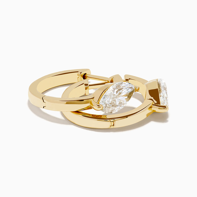 A pair of Lab Grown Diamond Marquise Huggie Earrings in 14K yellow gold, each with sparkling diamonds, shown against a plain white background.