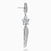 The 18K White Gold Diamond Shooting Star Linear Drop Earrings showcase a central star design with a long, pointed diamond-encrusted dangle, displayed on a plain white background.