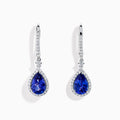 The Nahla 14K White Gold Tanzanite and Diamond Dangle Halo Earrings feature teardrop-shaped tanzanite stones surrounded by sparkling diamonds, set in elegant white gold and displayed against a white background.