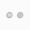 A pair of 14K White Gold Lab Grown Diamond Earrings with a central round diamond and a halo of smaller lab grown diamonds, set against a white background.
