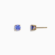 The 14K Yellow Gold Tanzanite Stud Earrings each showcase a round, faceted tanzanite in a four-prong setting, displayed on a white background.