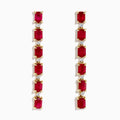 The 14K Yellow Gold Ruby and Diamond Linear Drop Earrings showcase alternating rectangular rubies and small round diamonds arranged vertically for an elegant, modern look.