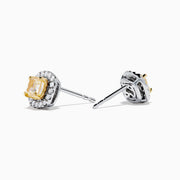 The Canare 18K Two Tone Gold Yellow Cushion Yellow and White Diamond Stud Earrings feature cushion cut yellow diamonds, each encircled by a halo of small round white stones, displayed on a plain white background.