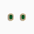 The 14K Yellow Gold Emerald and Diamond Halo Stud Earrings showcase rectangular green gemstones encircled by round and baguette-cut diamonds, displayed on a plain white background.