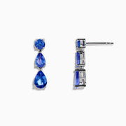 The Nahla Siri 925 Silver Tanzanite Drop Earrings feature three blue gemstones—one round and two teardrop-shaped—in varying blue shades, set against a white background.