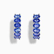 The Nahla Siri 925 Silver Tanzanite Hoop Earrings feature five oval tanzanite gemstones in prong settings, elegantly crafted from sterling silver and showcased against a plain white background.